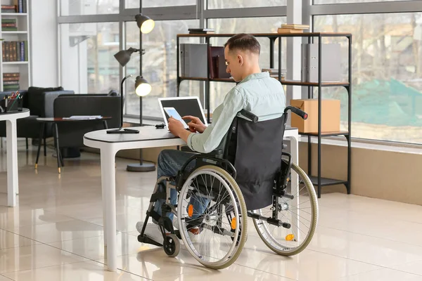 坐轮椅在办公室工作的年轻人 — 图库照片