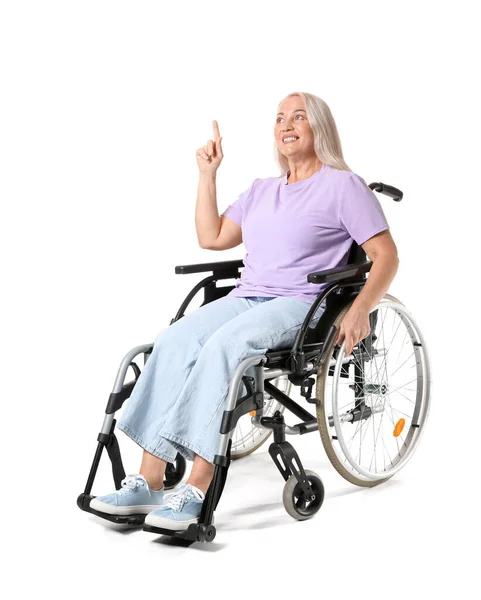 坐在轮椅上的成熟女人指着白色的东西 — 图库照片