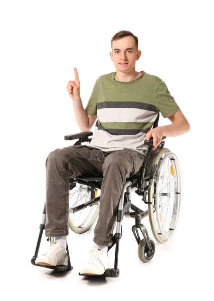 坐在轮椅上的年轻人指着白色背景的东西 — 图库照片