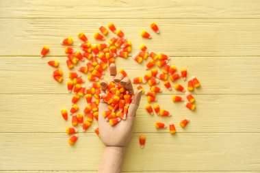 Tahta elli, Cadılar Bayramı şekerli, sarı ahşap arka planda mısır.