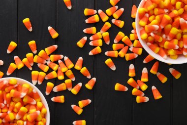 Siyah ahşap arka planda Cadılar Bayramı şekerli mısır kaseleri