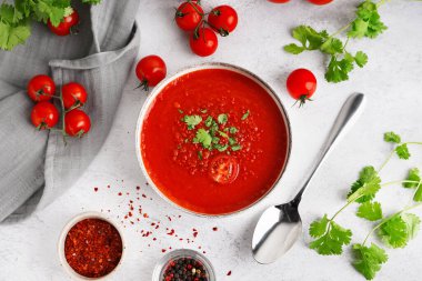 Hafif arkaplanda bir kase lezzetli domates çorbası.