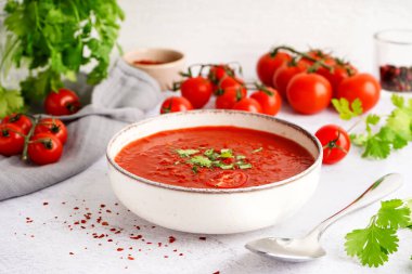 Hafif arkaplanda bir kase lezzetli domates çorbası.