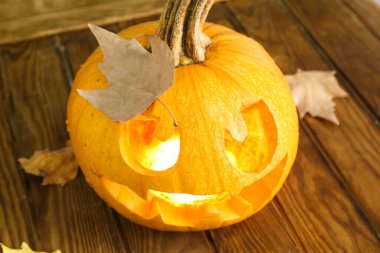 Balkabağı Jack-O-Lantern ahşap masada, yakın plan