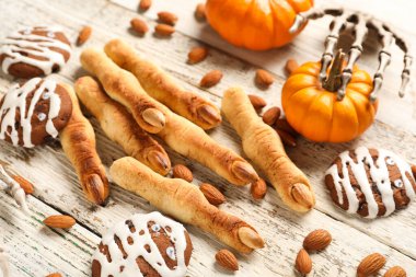 Badem fıstıklı Cadılar Bayramı kurabiyeleri, balkabağı ve iskelet elli beyaz ahşap arka plan, yakın plan