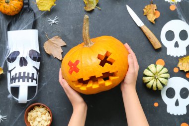Balkabağı Jack-O-Lantern balkabağı ve arka planda düşmüş yaprakları olan kadın.