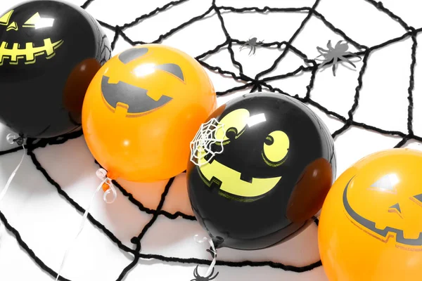 Halloween balloons and spider web on white background, closeup