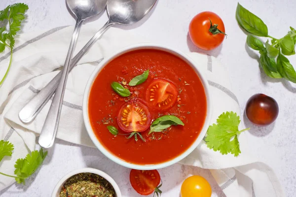 Bowl with tasty tomato soup on light background