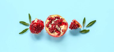 Açık mavi zemin üzerinde lezzetli olgun nar parçaları