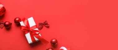 Kırmızı zemin üzerinde noel dekoru ve hediye kutusu metin ve üst görünüm için boşluk