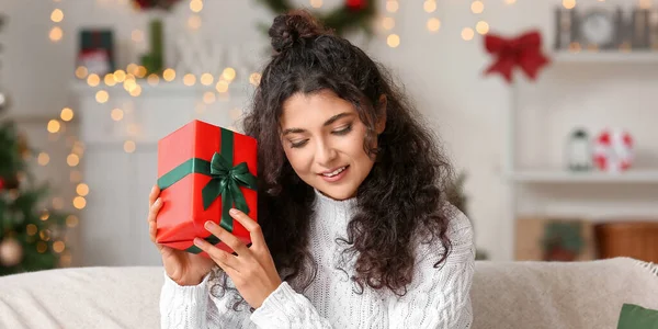 幸せな若いです女性とともにクリスマスプレゼントに家 — ストック写真