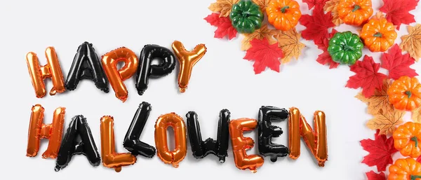 Balonlardan, kabaklardan ve beyaz arkaplanda sonbahar yapraklarından oluşan Cadılar Bayramınız kutlu olsun.