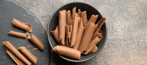 Arkaplanda lezzetli çikolata kıvırcıkları olan bir kase.