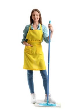 Beyaz arka planda yer paspası olan sarı önlüklü genç bir kadın.