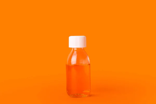 橙色背景的咳嗽糖浆瓶 — 图库照片