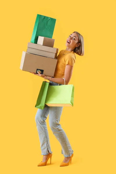 Mooie Jonge Vrouw Met Credit Card Pakketten Boodschappentassen Gele Achtergrond — Stockfoto