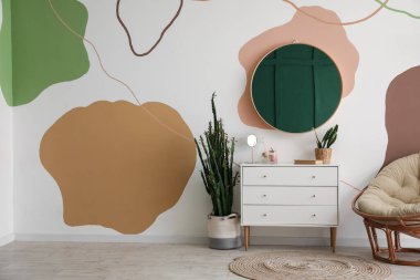 Aynalı, çekmeceli ve koltuklu şık bir oda.