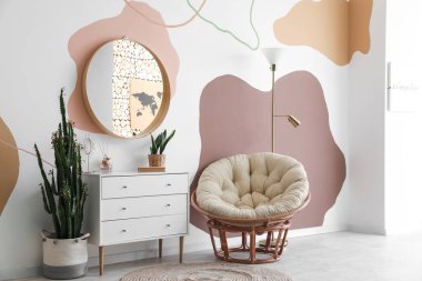 Aynalı, çekmeceli ve koltuklu şık bir oda.