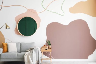 Ayna, kanepe ve masalı şık bir oda.