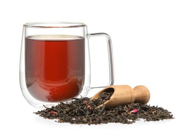 Bir bardak siyah çay ve beyaz arka planda kuru yapraklar.