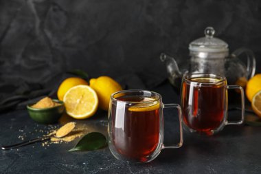 Koyu arkaplanda limonlu bir bardak siyah çay, yakın plan.