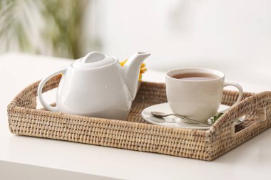 Kafedeki masada bir fincan sıcak çay ve demlik