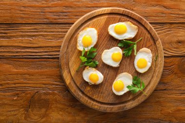 Ahşap arka planda lezzetli kızarmış bıldırcın yumurtaları olan bir tahta.