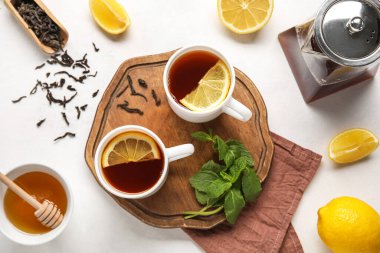 Siyah çay, limon, nane ve bal dolu tahta beyaz arka planda