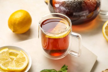 Siyah çay ve limonlu tahta beyaz arka planda, yakın plan.