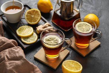 Siyah çay bardakları ve koyu arkaplanda limonla duruyor, yakın plan.