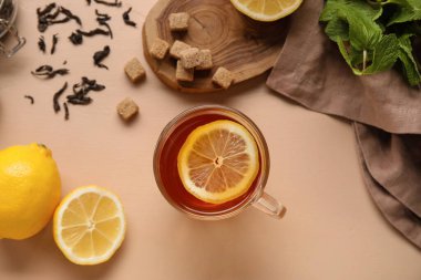 Bej arka planda limonlu bir bardak siyah çay, yakın plan.
