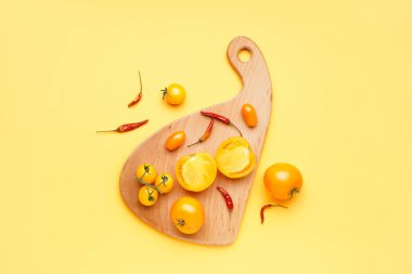 Taze domatesli ahşap tahta ve arka planda kurutulmuş kırmızı biber.