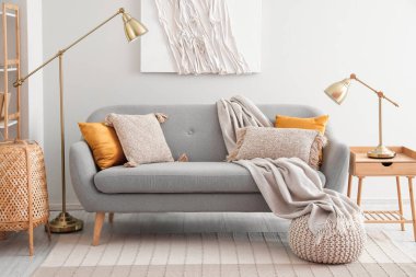 Aydınlık oturma odasında yastıklı ve ekoseli modern kanepe.