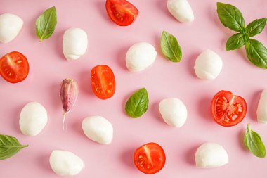 Renkli arkaplanda lezzetli mozzarella peyniri, fesleğen ve domates kompozisyonu