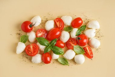 Renkli arkaplanda lezzetli mozzarella peyniri, domates ve fesleğen kompozisyonu