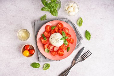 Lezzetli mozzarella peyniri, domates, fesleğen ve hafif arka planda yağlı kompozisyon