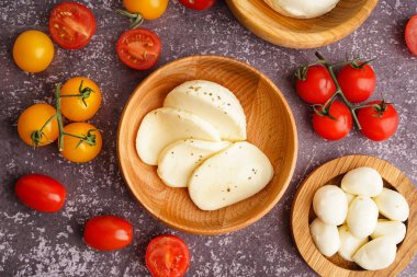 Bir kase lezzetli mozzarella peyniri ve arkaplanda domates.