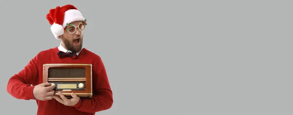 サンタハットの面白い男とテキストのためのスペースを持つ灰色の背景にレトロなラジオ受信機 — ストック写真