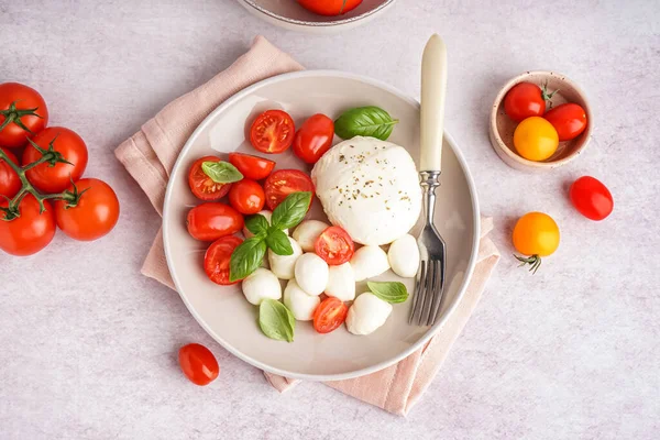 Talerz Pysznym Serem Mozzarella Bazylią Pomidorami Jasnym Tle — Zdjęcie stockowe