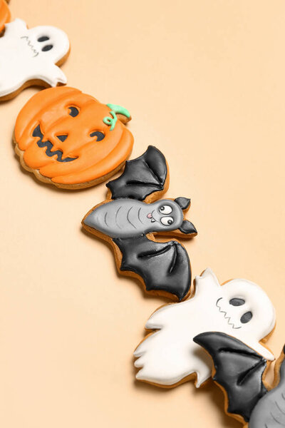 Tasty Halloween cookies on beige background, closeup