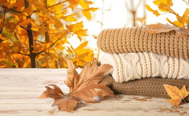 Sonbahar bahçesindeki masada bir yığın kalın kazak.