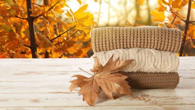 Sonbahar bahçesindeki masada bir yığın kalın kazak.