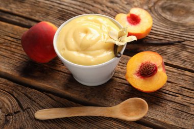 Lezzetli vanilyalı puding ramekin ve ahşap arka planda şeftali