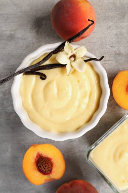 Lezzetli vanilyalı puding ve arkaplanda şeftali, yakın plan.
