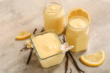 Kavanoz ve kase lezzetli vanilyalı puding ve arkaplanda limon.