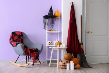 Salonun içinde koltuk, raf ve Cadılar Bayramı dekorasyonu var.