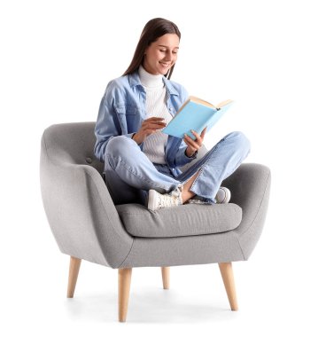Beyaz arka planda yumuşak koltukta kitap okuyan güzel bir kadın.
