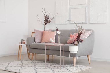 Gri kanepeli, masalı ve boş posterli şık bir oda.