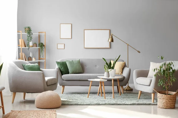 Interior of modern living room with houseplants, sofa and armchairs