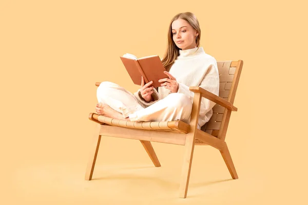 Bej Arka Planda Koltukta Kitap Okuyan Genç Bir Kadın — Stok fotoğraf